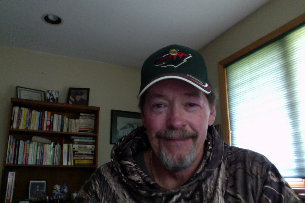 Dan happily working from home, dressed in his favorite baseball cap and sweater.