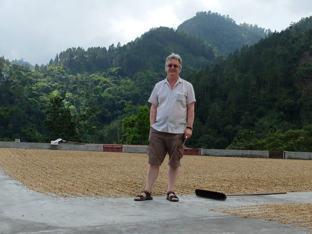 Writing for the web - Nick on a coffee research trip in Jamaica. Those are coffee beans drying on the concrete.