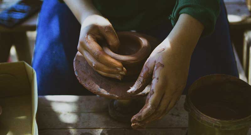 Woman working on an economy pottery wheel