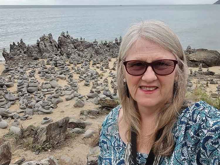 Lesley visiting a shrine of small stacked stones.