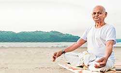 man meditating on beach